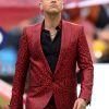 Robbie Williams red leopard-print suit featuring a bold red base with black leopard spots, tailored two-piece design including a slim-fit jacket with notch lapels and matching tapered trousers, all in a sleek, statement-making print ideal for stage or high-fashion events