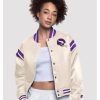 Women’s Minnesota Vikings full‑snap cream satin jacket featuring bold purple and gold team insignia, a full button front, ribbed collar and cuffs, roomy sleeves, and a glossy satin finish for a sporty, show‑off game day look. Sources